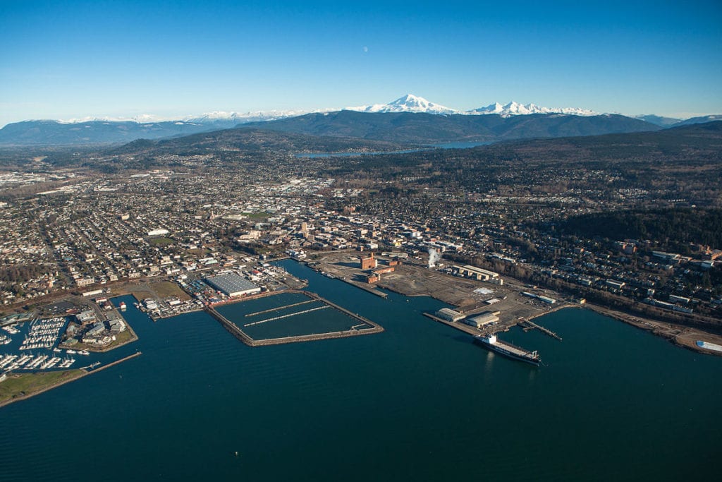 A Bellingham, WA aerial view showing harbor, land, and mountains