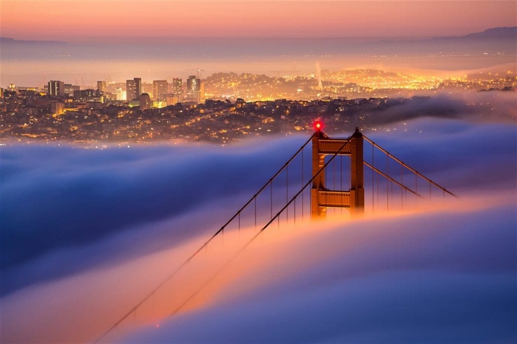 The San Francisco skyline behind a cloud-covered Golden Gate Bridge